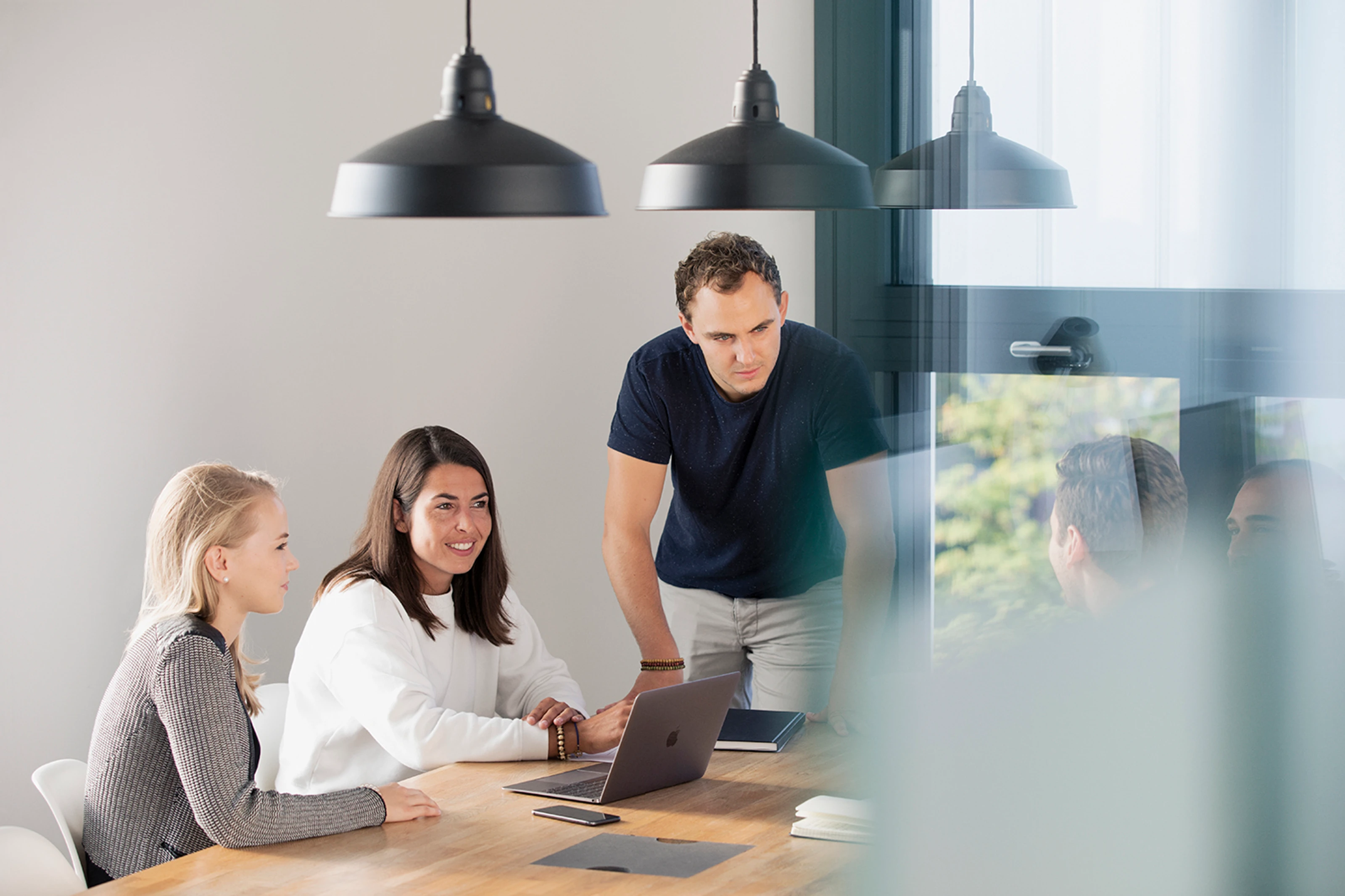 Team at a desk with laptops, working