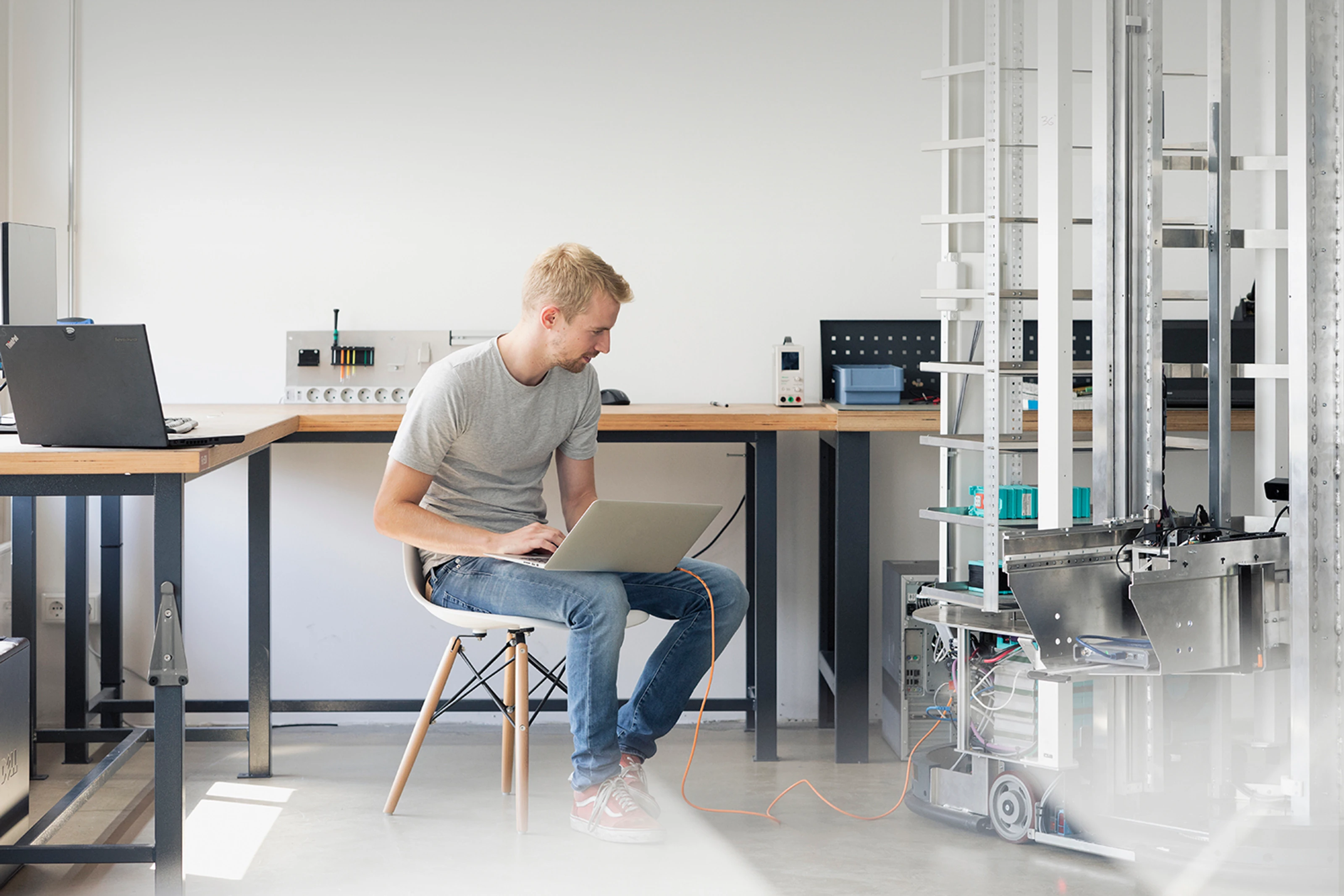 Two men in an office, working on computers with a product model on the screen