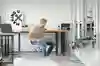 Mann mit Laptop, der an einer Maschine arbeitet
